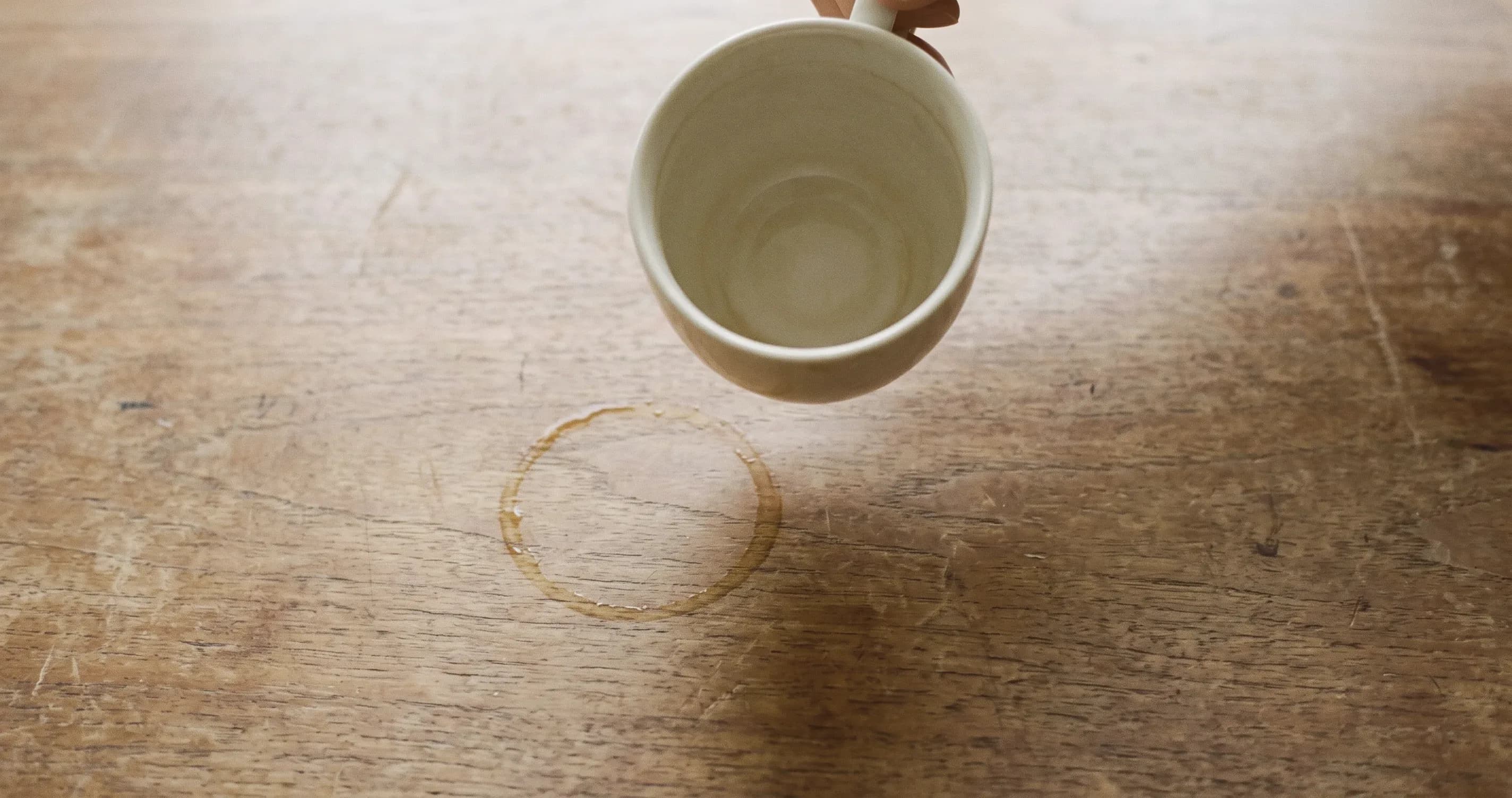 A used teacup leaving a faint ring on a wooden table.