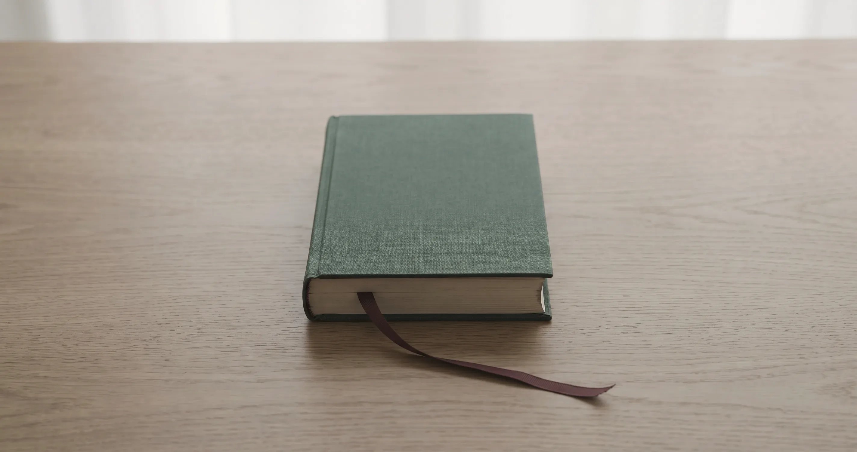 A bookmark left in the middle of a closed book on a table.