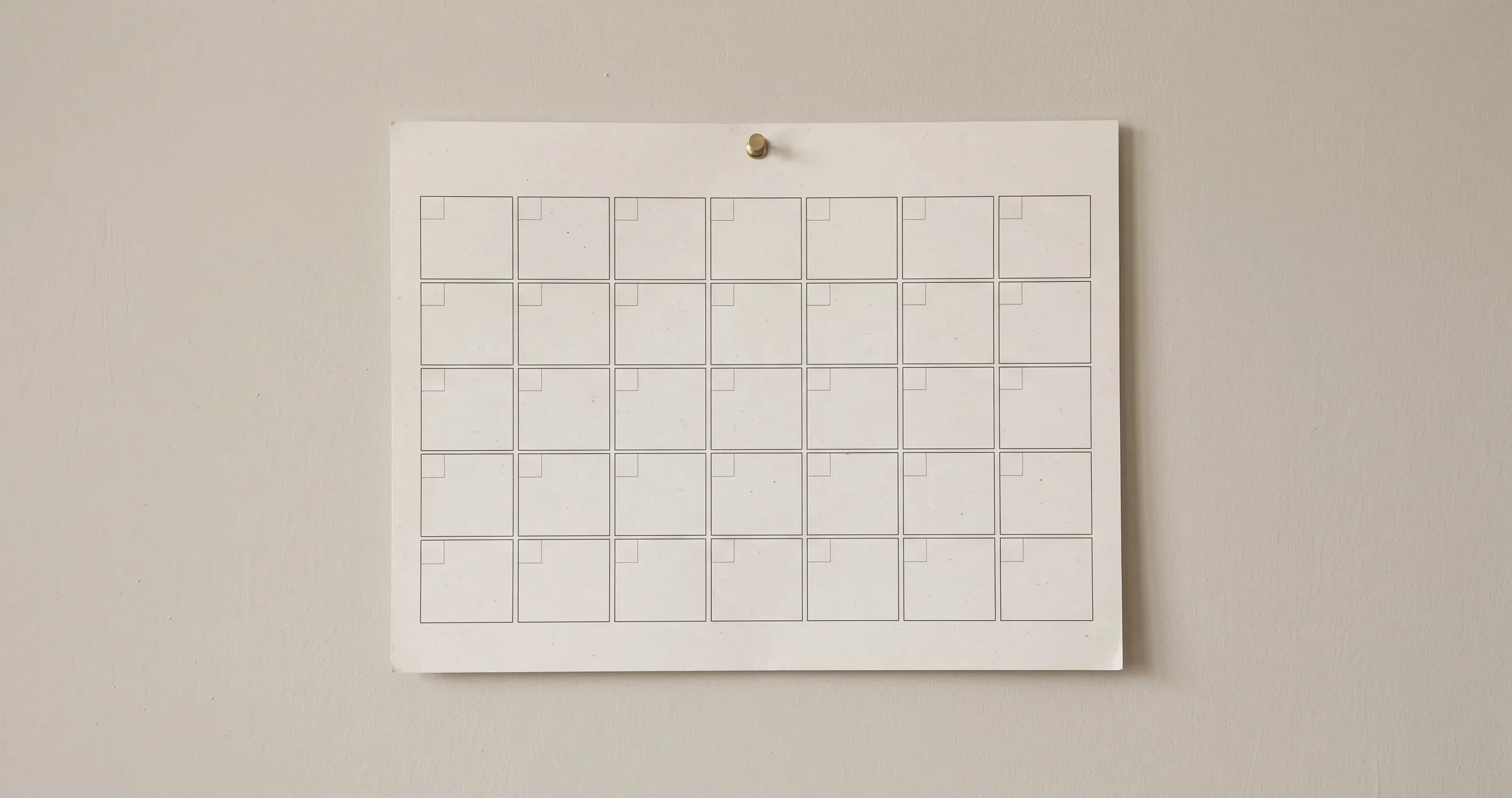 A wall calendar showing a single month, hanging on a plain wall.