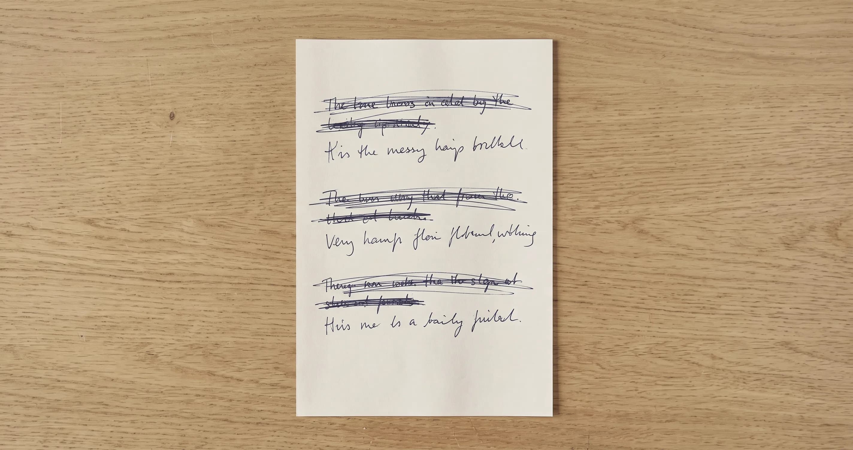 A sheet of paper with several lines crossed out and rewritten beneath each other.