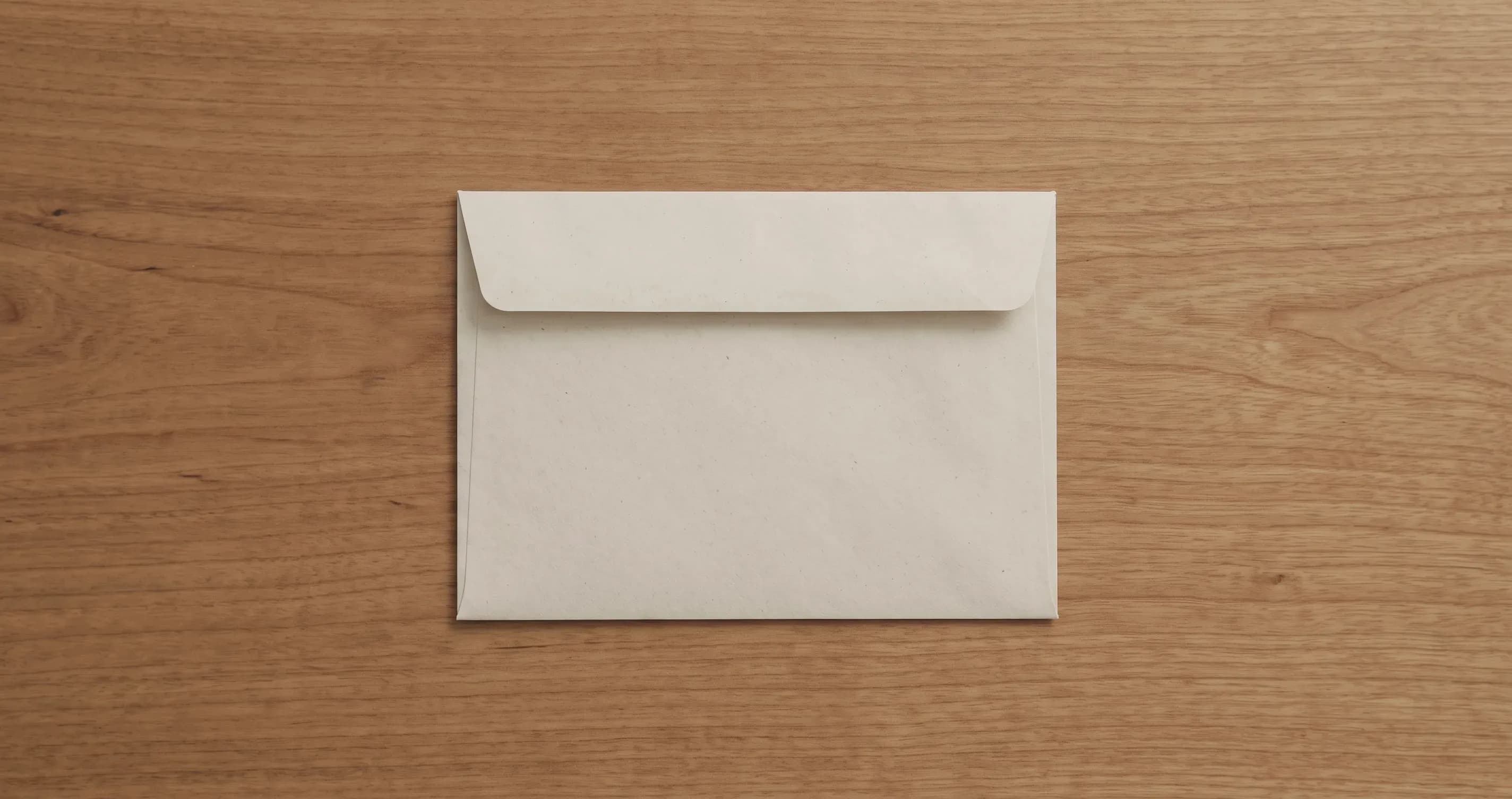 A sealed envelope on a plain table, addressed side down.