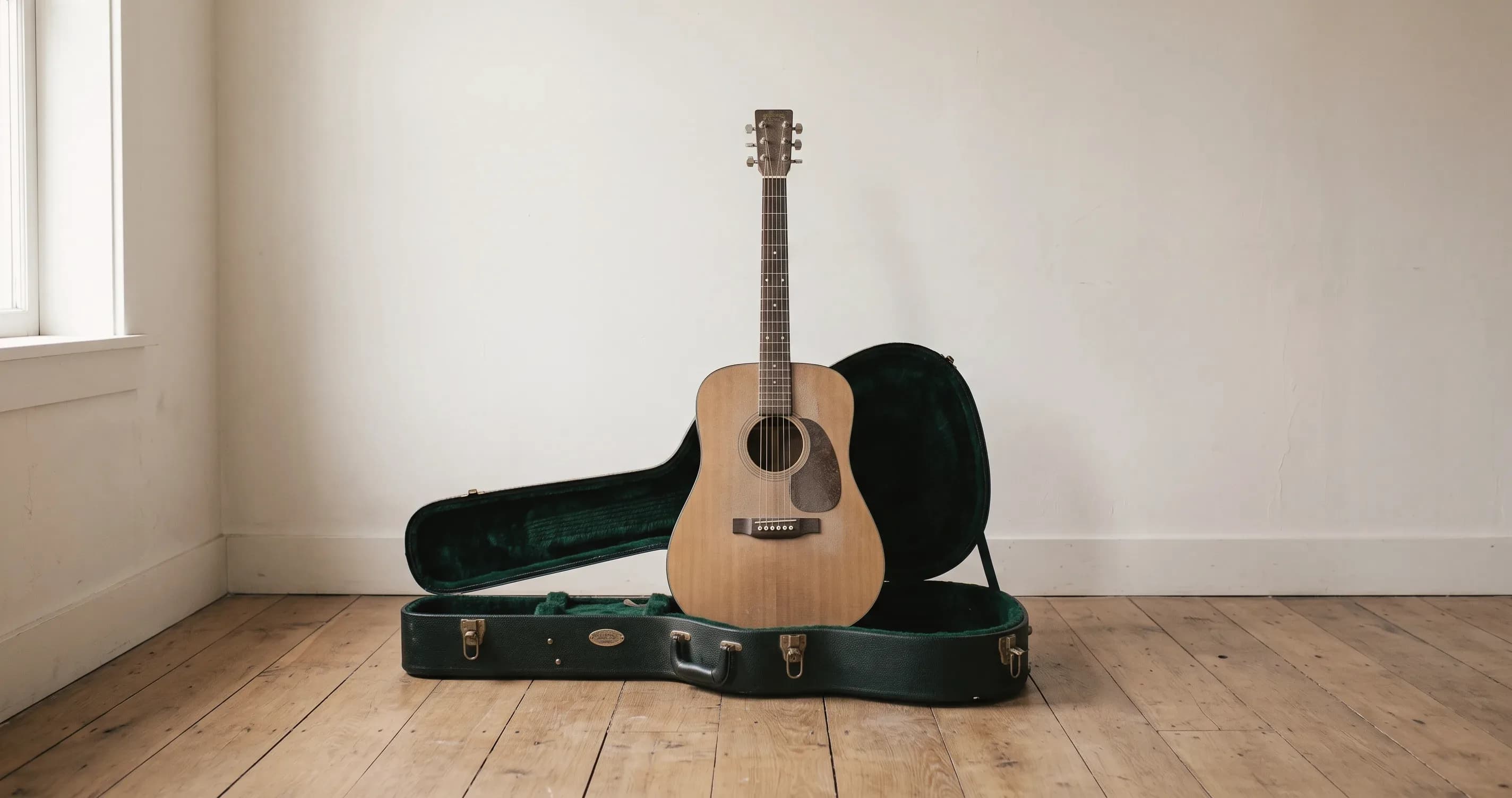 A guitar standing upright in its open case in an empty room.